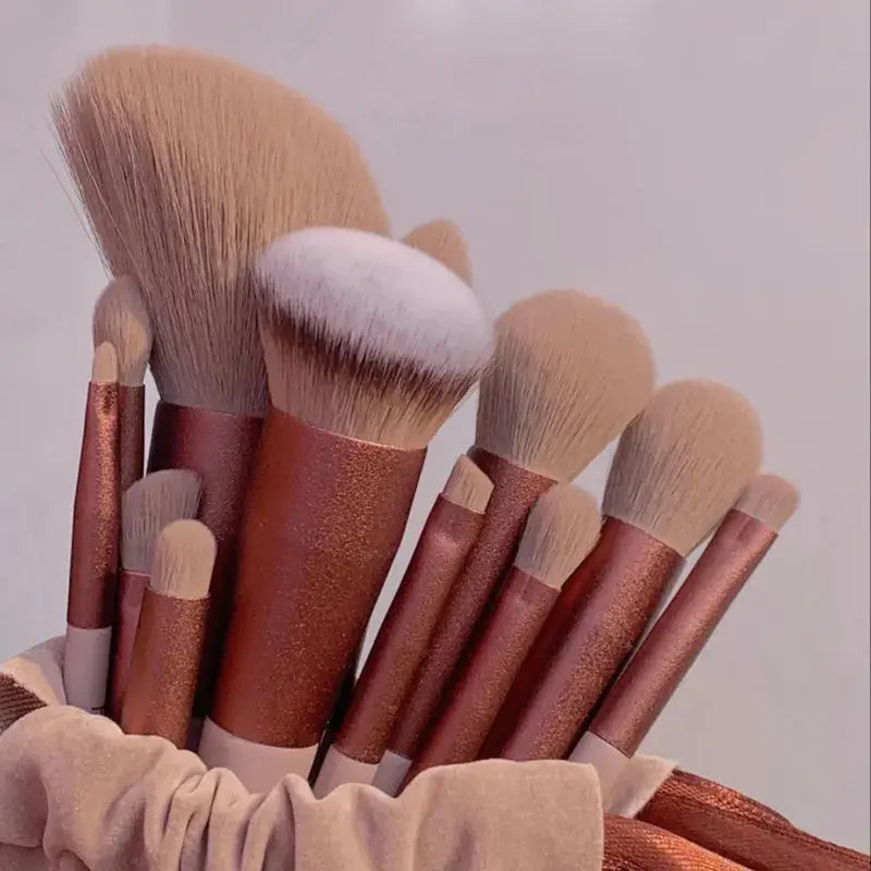 Set of makeup brushes with brown handles and beige bristles in a holder.